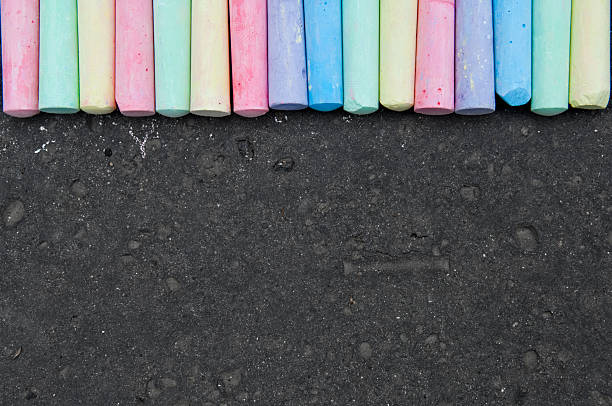 colores pastel de tiza en la acera en oscuro fondo de cemento. - acera fotografías e imágenes de stock