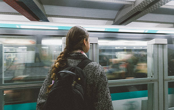 jeune femme attendant le train de la station de métro à paris - paris metro train photos et images de collection