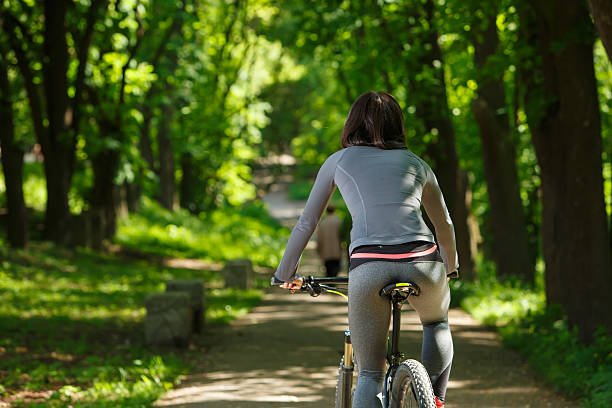 istock cyclist woman riding a bicycle in park 538346572