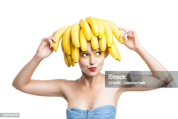 Excited Model With Bananas On Head Holding One In Hand Stock Photo - Download Image Now