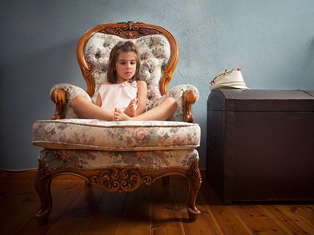 Portrait of cute little girl sitting on the armchair