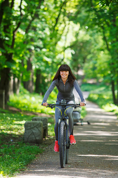 istock cyclist woman riding a bicycle in park 538350244