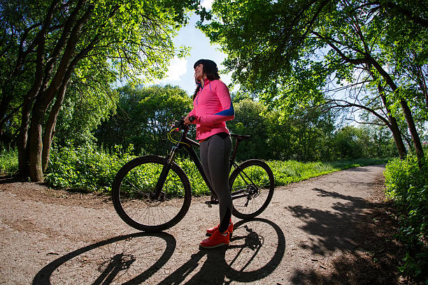 istock Young woman having fun riding a bicycle in the park. 538351460