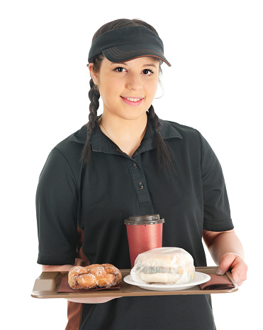 A pretty young waitress bringing the viewer a wrapped breakfast sandwich, twisty donut and cup of coffee.  On a white background.