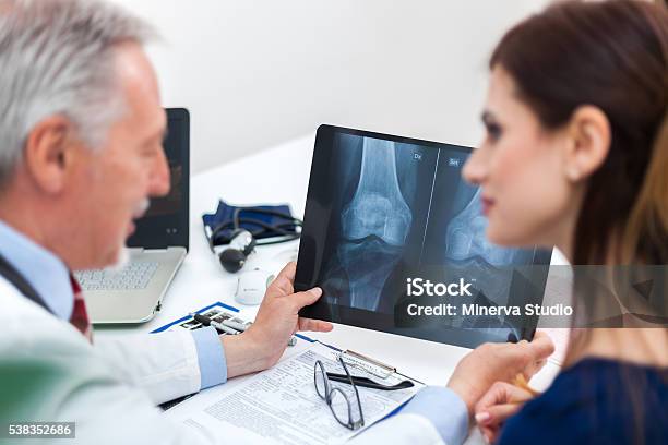 Doctor Showing A Radiography To His Patient Stock Photo - Download Image Now - Osteoporosis, Women, Doctor