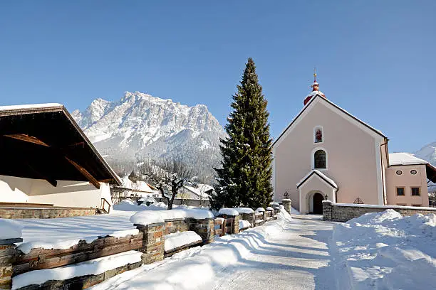 Parish church in Ehrwald with Zugspitze summit, Germany's highest mountain