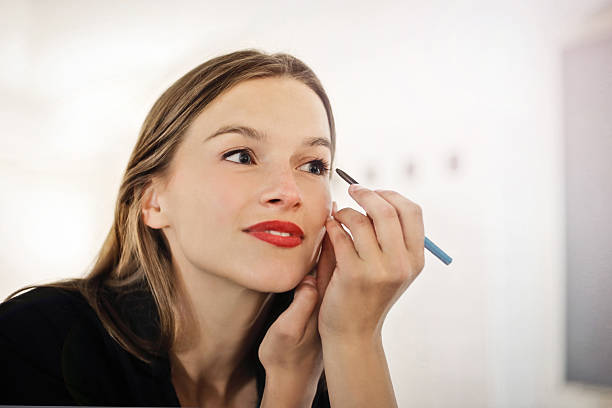 bella mujer poniendo maquillaje en - makeup pencils fotografías e imágenes de stock