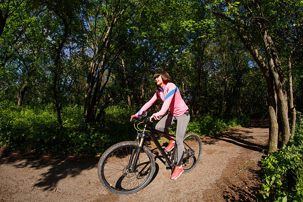 istock Young woman having fun riding a bicycle in the park. 538354258