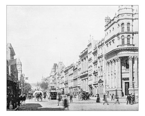 Antique photograph of Melbourne (Australia)-19th century:scene street Antique photograph of crowded street (Collins Street?) of Melbourne city centre (Australia) during the late 19th century, when the city had been founded about fifty years before: the vively street is busy with carriages, trams, carts and pedestrians on the sidewalks and two long lines of buildings overlooking the carriageway. Among the old Victorian buildings some can be recognised: on the left the clock tower of the Melbourne Town Hall melbourne street crowd stock illustrations