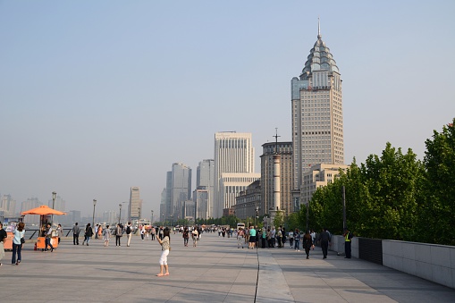 Shanghai, China- April 29, 2016: tourists sightseeing the Bund, a scenic waterfront area in central Shanghai. It is one of the most famous tourist destinations in Shanghai and houses buildings of various architectures.