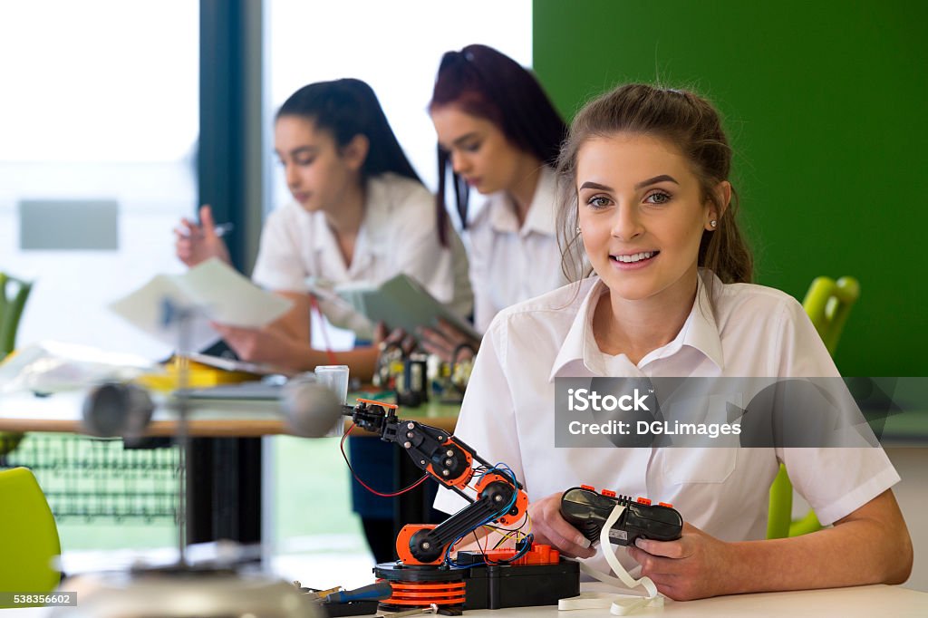 Design and Technology Lesson Adolescent girl in a design and technology lesson. She is smiling at the camera with a robotic arm that she is building infront of her. Student Stock Photo