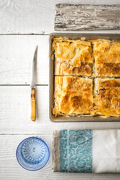 istock Greek pie spanakopita in metal pan  with table ware vertical 538356734