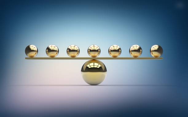 Seven gold balls balancing on one large gold ball
