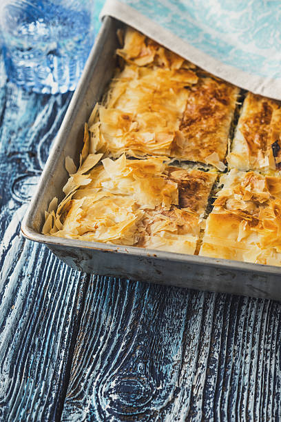 istock Greek pie spanakopita in metal pan  on  blue  table vertical 538357132