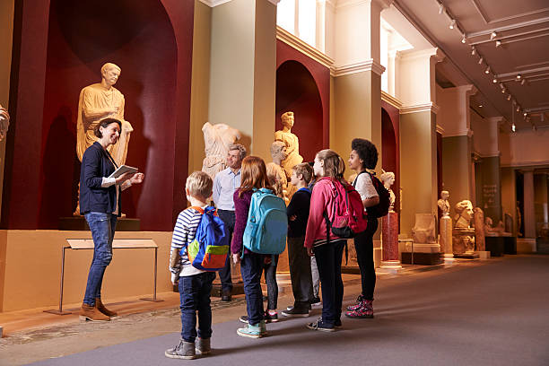 élèves et enseignant dans l'école excursion pour le musée - guising photos et images de collection