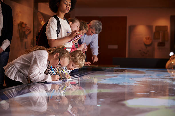 istock Pupils On Trip To Museum Looking At Map And Making 538358594