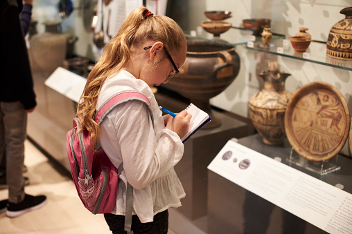 Estudiante observando un artefactos en caso de viaje a Museo photo