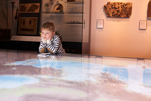 istock Boy On Trip To Museum Looking At Map And Writing In 538358958