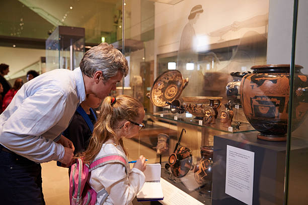 los profesores y alumnos observando un artefactos en exhibición en museo - antiquities fotografías e imágenes de stock