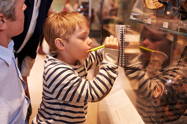 istock Family Looking At Artifacts In Glass Case On Trip 538359022
