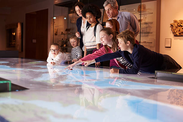 учащихся в школы поездке в музей смотрит на карте - museum стоковые фото и изображения