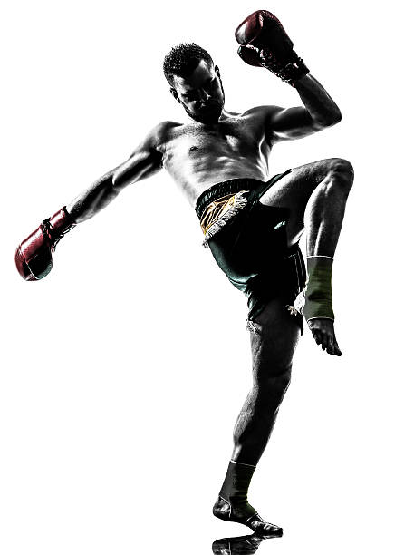 un hombre de boxeo tailandés de silhouette ejercicio - muay thai fotografías e imágenes de stock