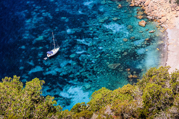 Top view of amazing blue water lagoon and anchored sailboat stock photo
