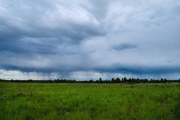 istock rain pours from clouds above the field 538361564