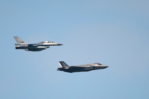 Swifterbant, The Netherlands - June 7, 2016: Lockheed Martin F-35 Lightning II and F16 Fighting Falcon of the Dutch Air Force flying in formation during a demonstration flight over The Netherlands to show the new F35 Joint Strike Fighter.