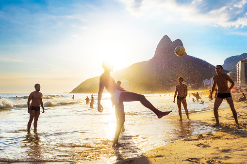 Rio de Janeiro, Brazil - December 19, 2015: Locals playing ball game at sunset in Ipanema beach, Rio de Janeiro, Brazil.