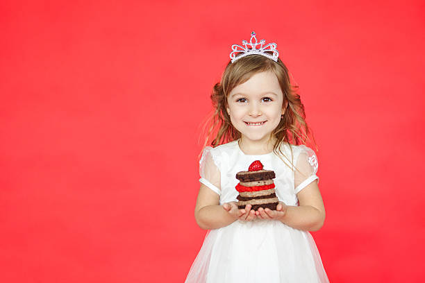 istock Cute kid girl holding a tasty mini cake 538363374