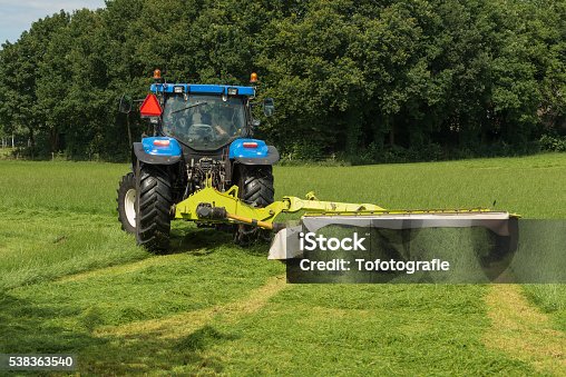 istock pasture mowing with blue tractor and mower 538363540