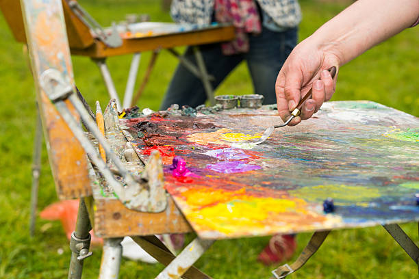 istock Male hand mixing oil paint on an old multiclored palette 538367192