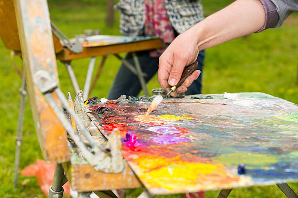 istock Male hand mixing light colors with a paletteknife 538367390