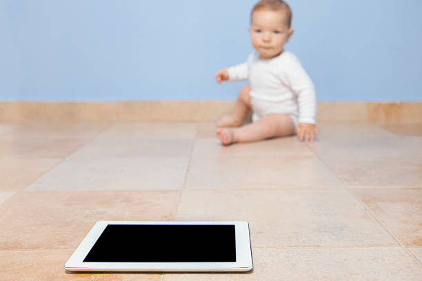 menino de pesquisa para um comprimido - baby tile crawling tiled floor imagens e fotografias de stock