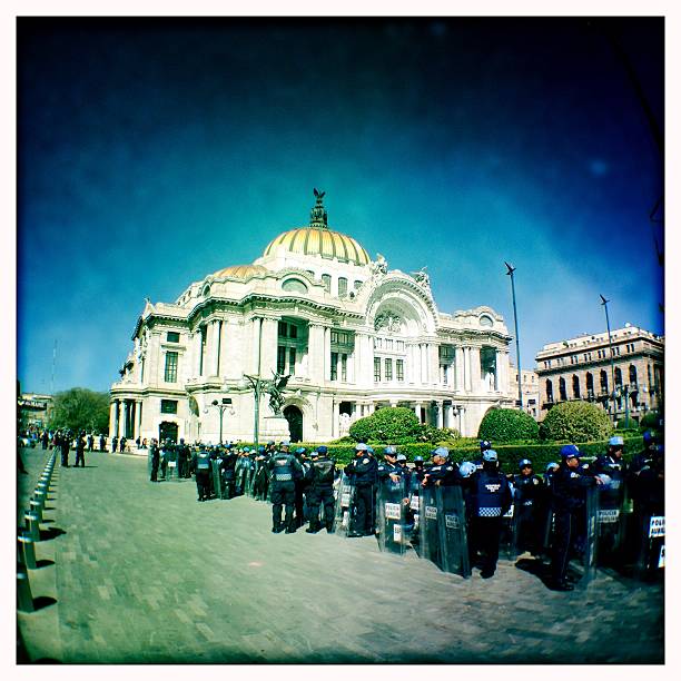 Palace of Fine Arts in Mexico City Mexico City, Mexico - February 9, 2015: Riot police at the ready during demonstrations in downtown. In front of Palacio de Bellas Artes (Spanish for Palace of Fine Arts). Mexico City's main opera and theatre house. riot police stock pictures, royalty-free photos & images