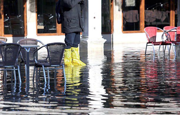 istock venice people with gaiters at high tide 538367721