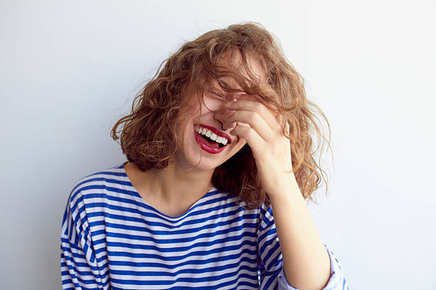 笑う女性、カーリーヘアの白い壁 - 笑う ストックフォトと画像