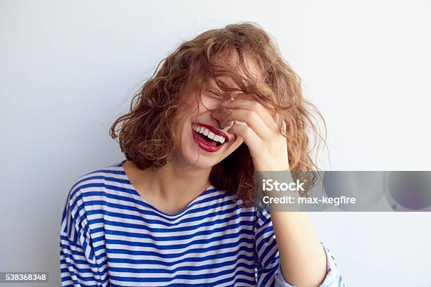 Laughing Woman With Curly Hair On White Wall Stock Photo - Download Image Now - Laughing, Women, Teenage Girls