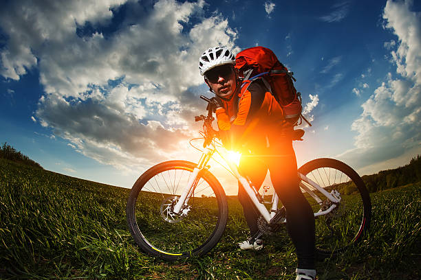 istock biker in orange jersey riding on green summer field 538369572