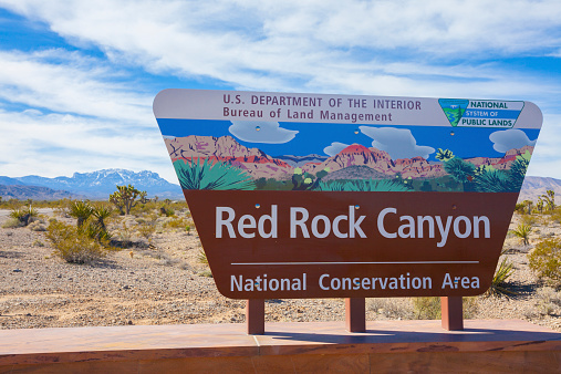 Las Vegas, USA - February 16, 2015: A photo of the Red Rock Canyon sign. he Red Rock Canyon National Conservation Area in Nevada. It is located about 15 miles west of the Las Vegas Strip. The area is visited by over 1 million visitors each year.