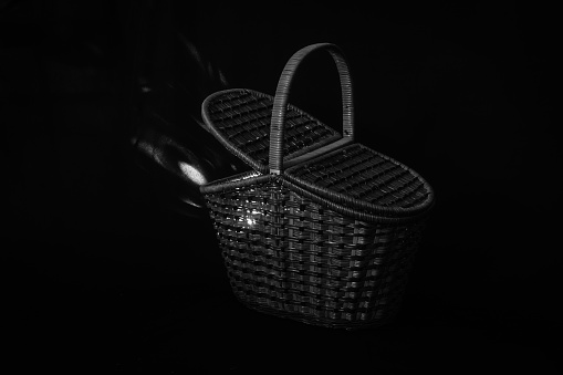 Illuminated basket in black and white. The light is breaking out from limited space.