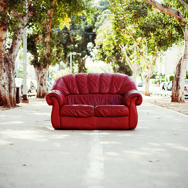 red vintage leather sofa on the street stock photo