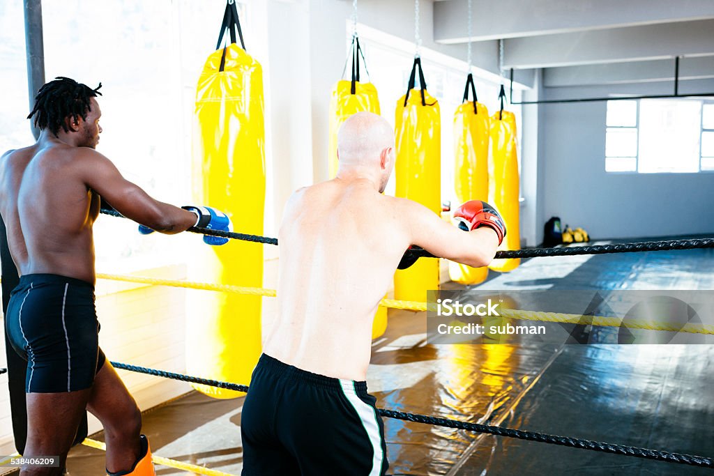Fight Club Two contact fighters standing in the boxing ring in the boxing studio. Boxing - Sport Stock Photo