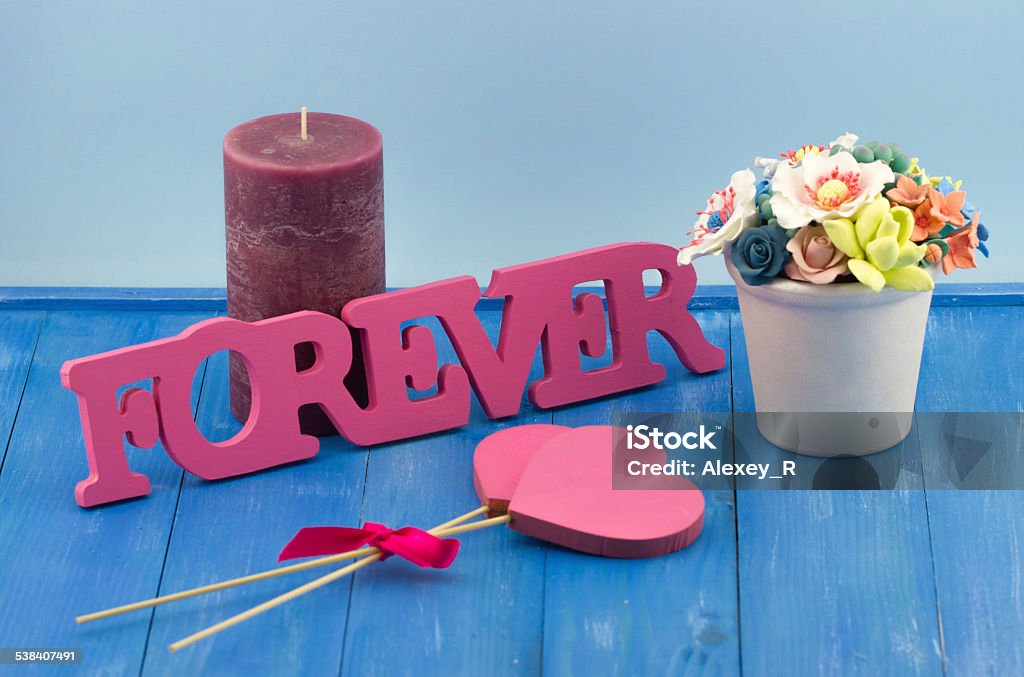 Candle, hearts, FOREVER 3d text, a pot of artificial flowers Valentines Day concept. Candle, hearts, FOREVER 3d text , a pot of artificial flowers on wooden vintage blue background 2015 Stock Photo