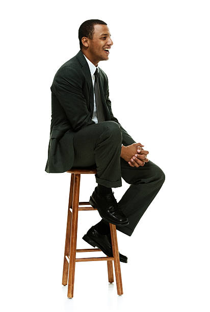 istock Cheerful businessman on stool & looking away 538412423