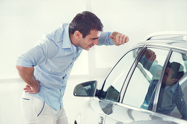 istock Man examining a car in a showroom. 538412853