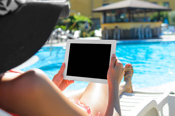 istock Woman with tablet at swimming pool 538413319