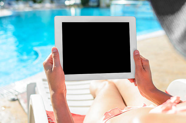 istock Woman with tablet at swimming pool 538413325