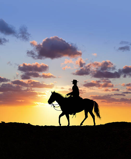 istock Cowboy riding lonely through the wilderness at sunset 538445998